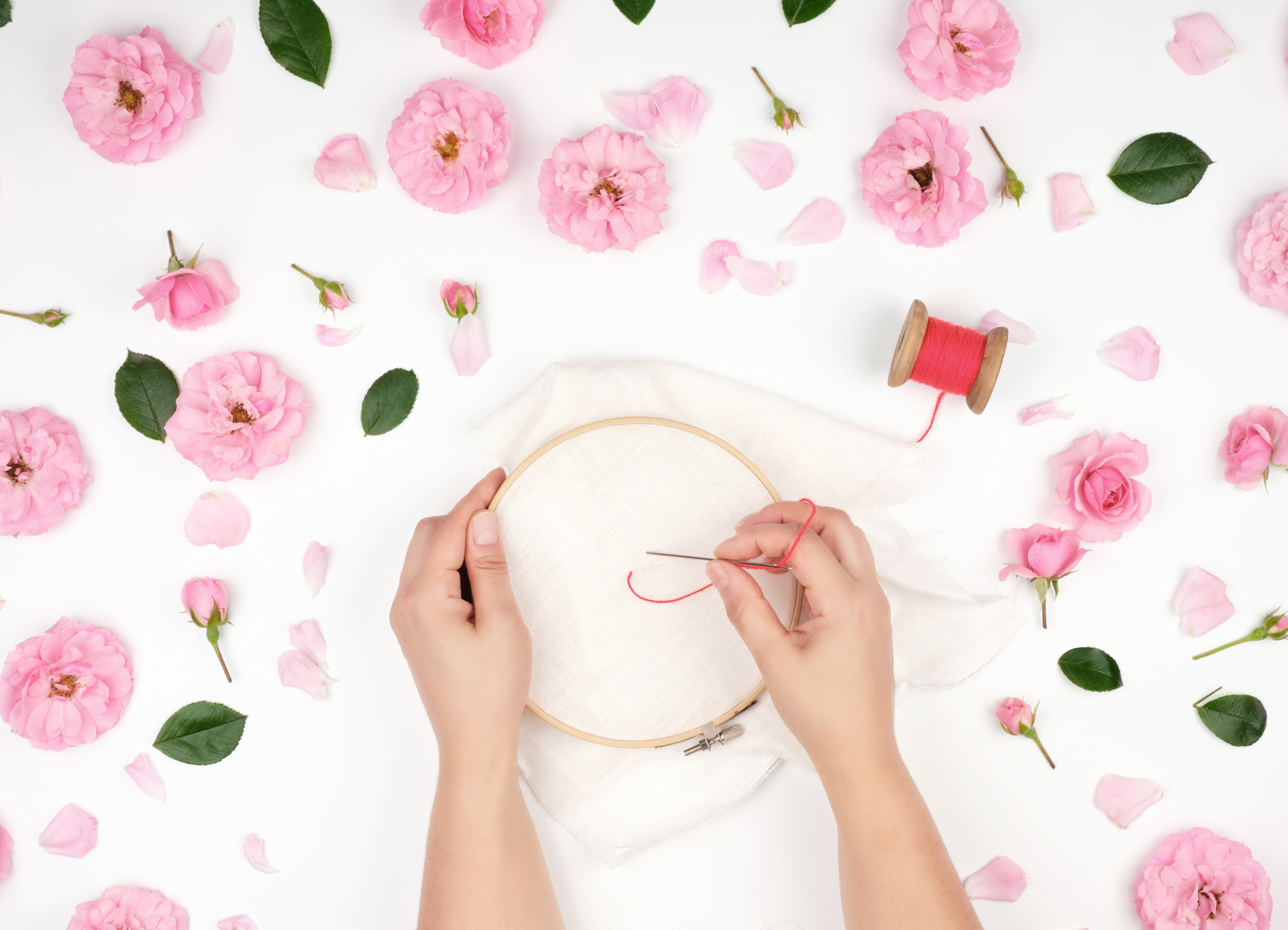 Artist hands stitching a floral motif